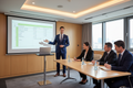 Professional trainer presenting housekeeping budget Excel spreadsheet to hotel managers in corporate training session